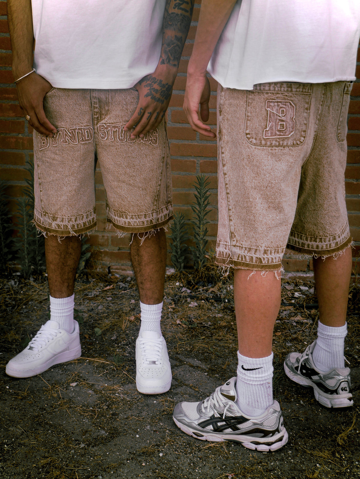 Two people wearing BYND STUDIOS washed brown shorts with sneakers